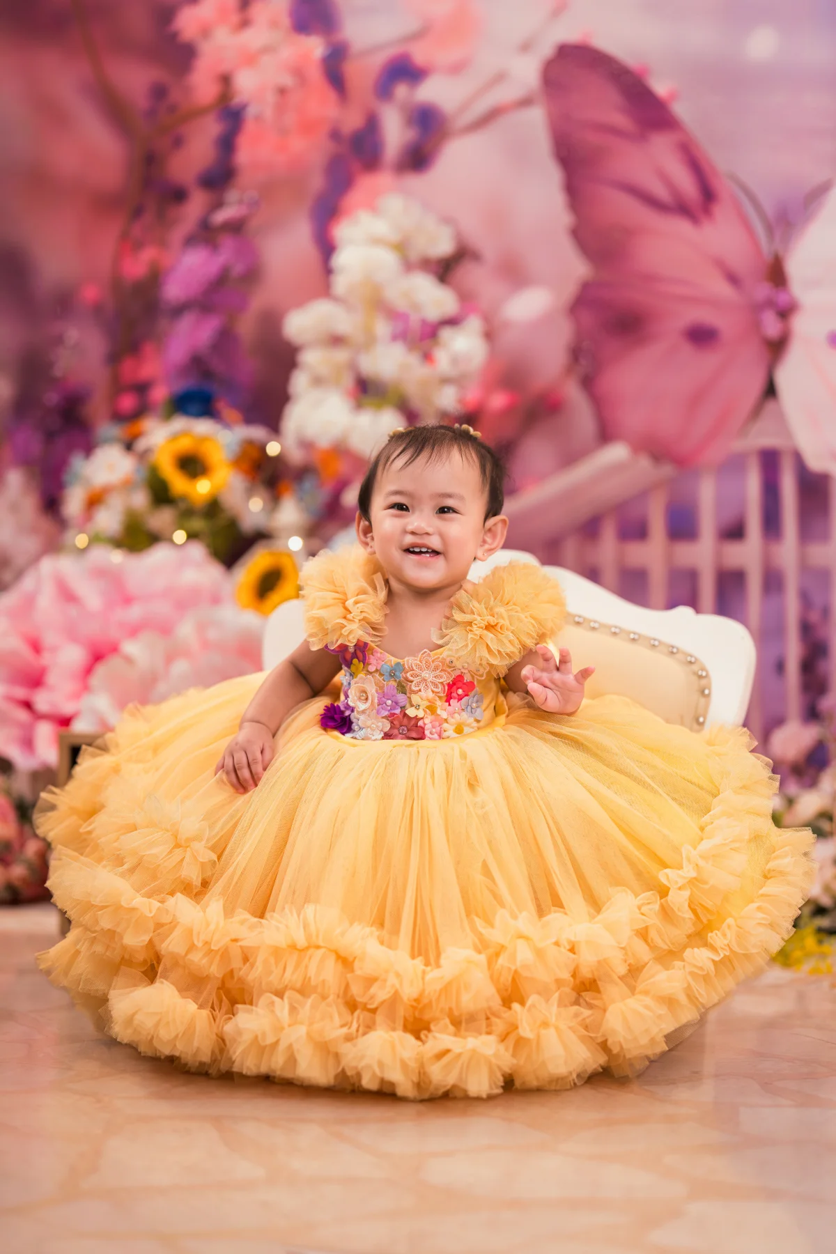 Our Little One smiling in a yellow birthday dress